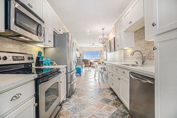 a kitchen with stainless steel appliances granite countertop a stove a sink and a microwave