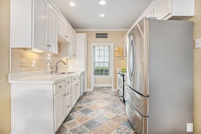 a kitchen with granite countertop a sink stove and refrigerator
