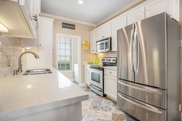 a kitchen with white cabinets and stainless steel appliances