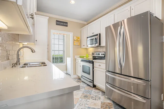 a kitchen with white cabinets and stainless steel appliances