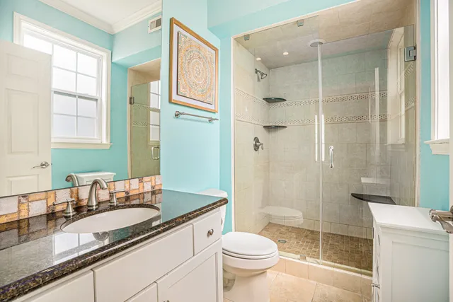 a bathroom with a granite countertop sink toilet and shower