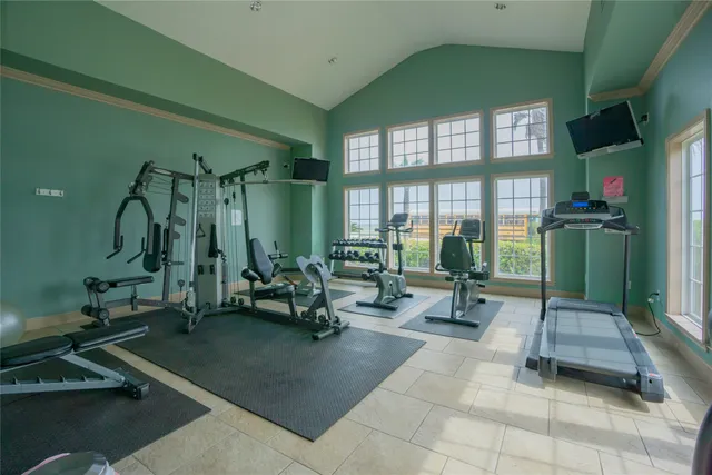 a living room with furniture a gym equipment and a large window