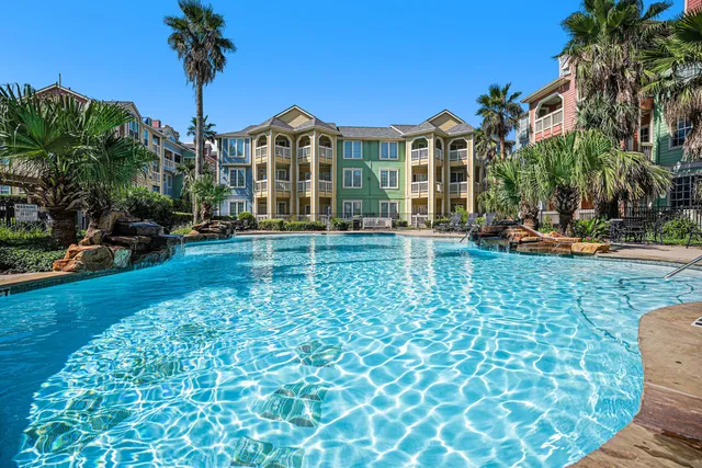 a view of a building with a yard and palm trees