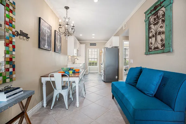 a living room with furniture a chandelier and a dining table