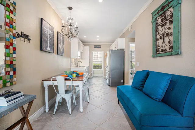 a living room with furniture a chandelier and a dining table