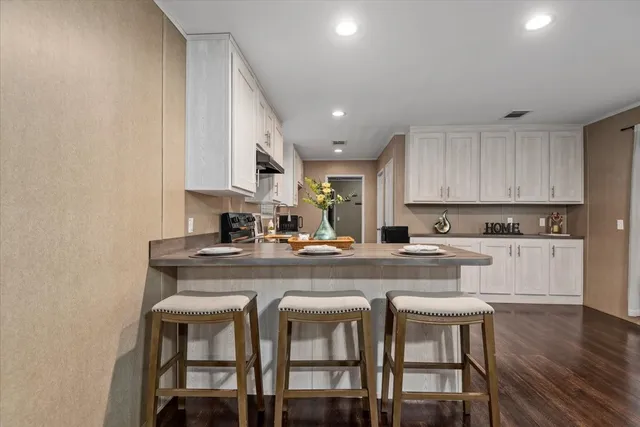 a kitchen with kitchen island cabinets and chairs in it
