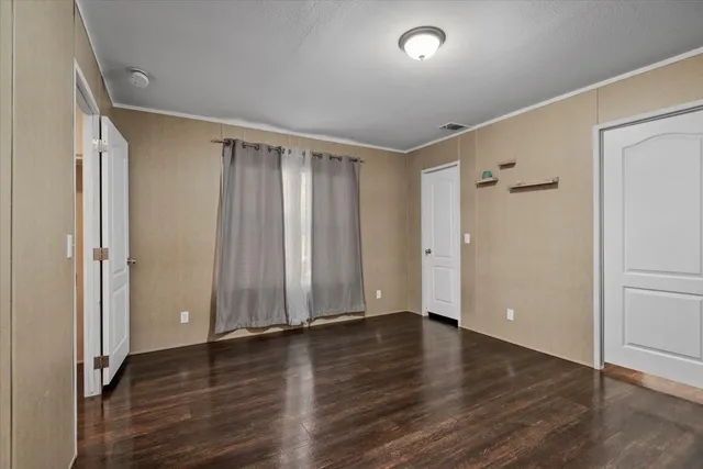 an empty room with wooden floor and a window