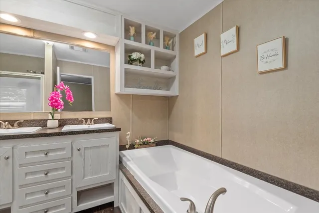 a bathroom with a granite countertop sink a mirror and a bathtub