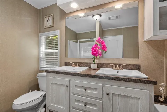 a bathroom with a sink vanity mirror and toilet