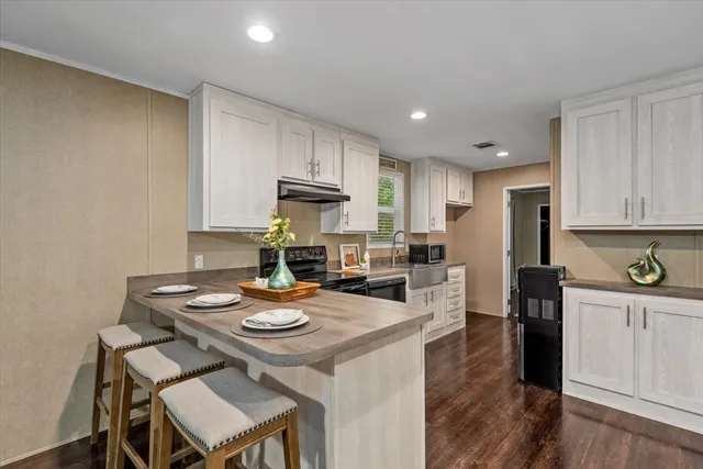 a kitchen with a sink a stove and chairs