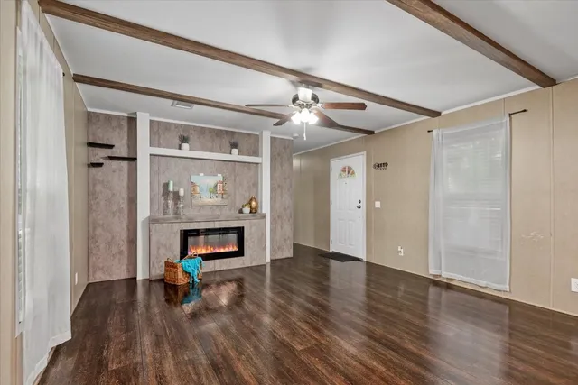 a view of an empty room with a fireplace and wooden floor