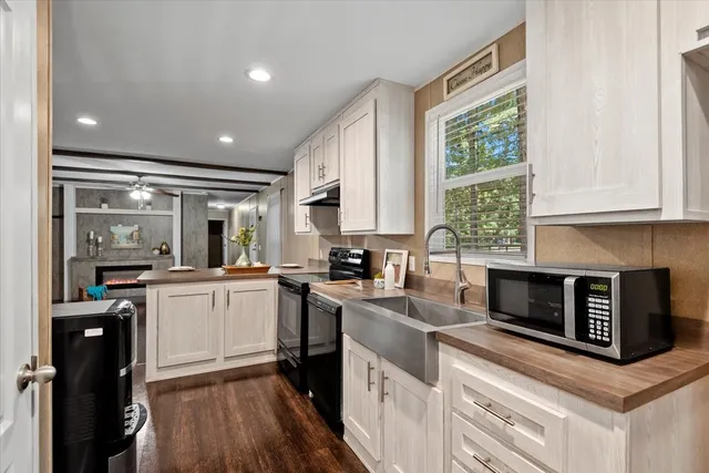 a kitchen with granite countertop kitchen island stainless steel appliances a stove sink and cabinets
