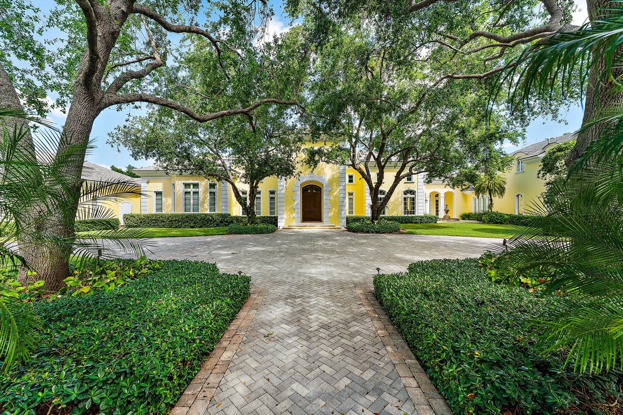 124 Bears Club Drive Jupiter, FL 33477 - Photo 2 of 67 a front view of a house with a yard