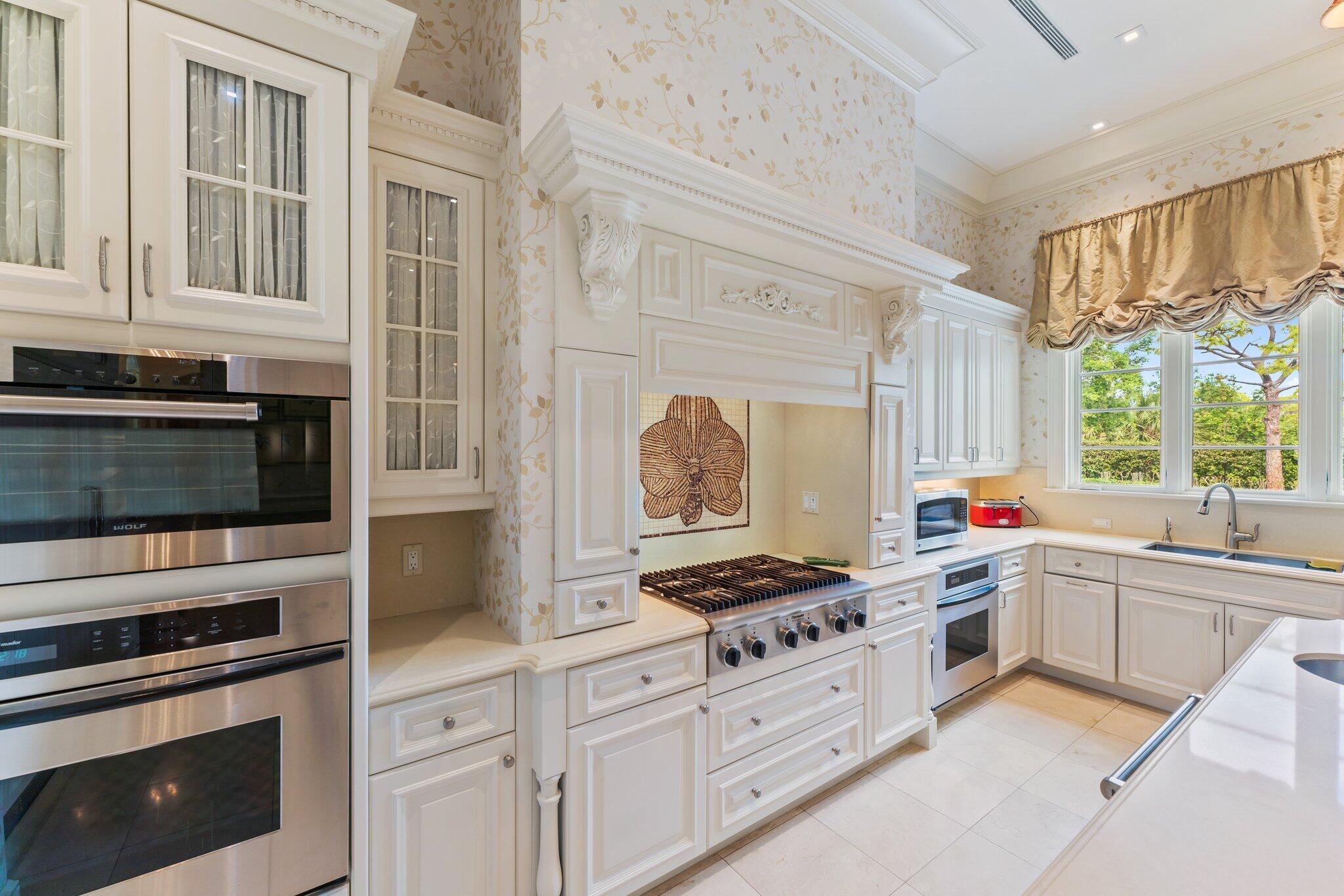 124 Bears Club Drive Jupiter, FL 33477 - Photo 30 of 67 a kitchen with stainless steel appliances a stove sink and cabinets