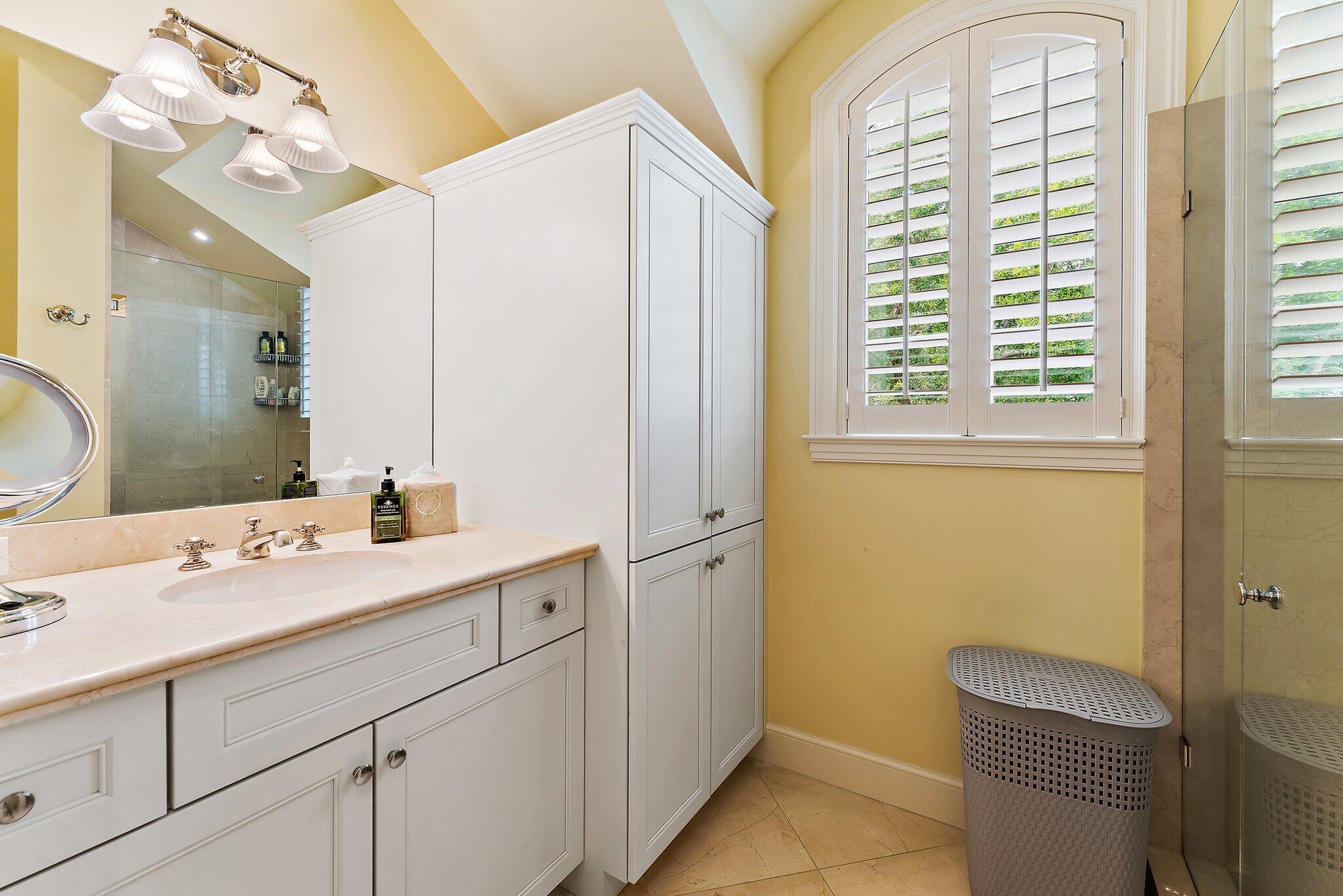 124 Bears Club Drive Jupiter, FL 33477 - Photo 50 of 67 a bathroom with a sink a vanity and a mirror