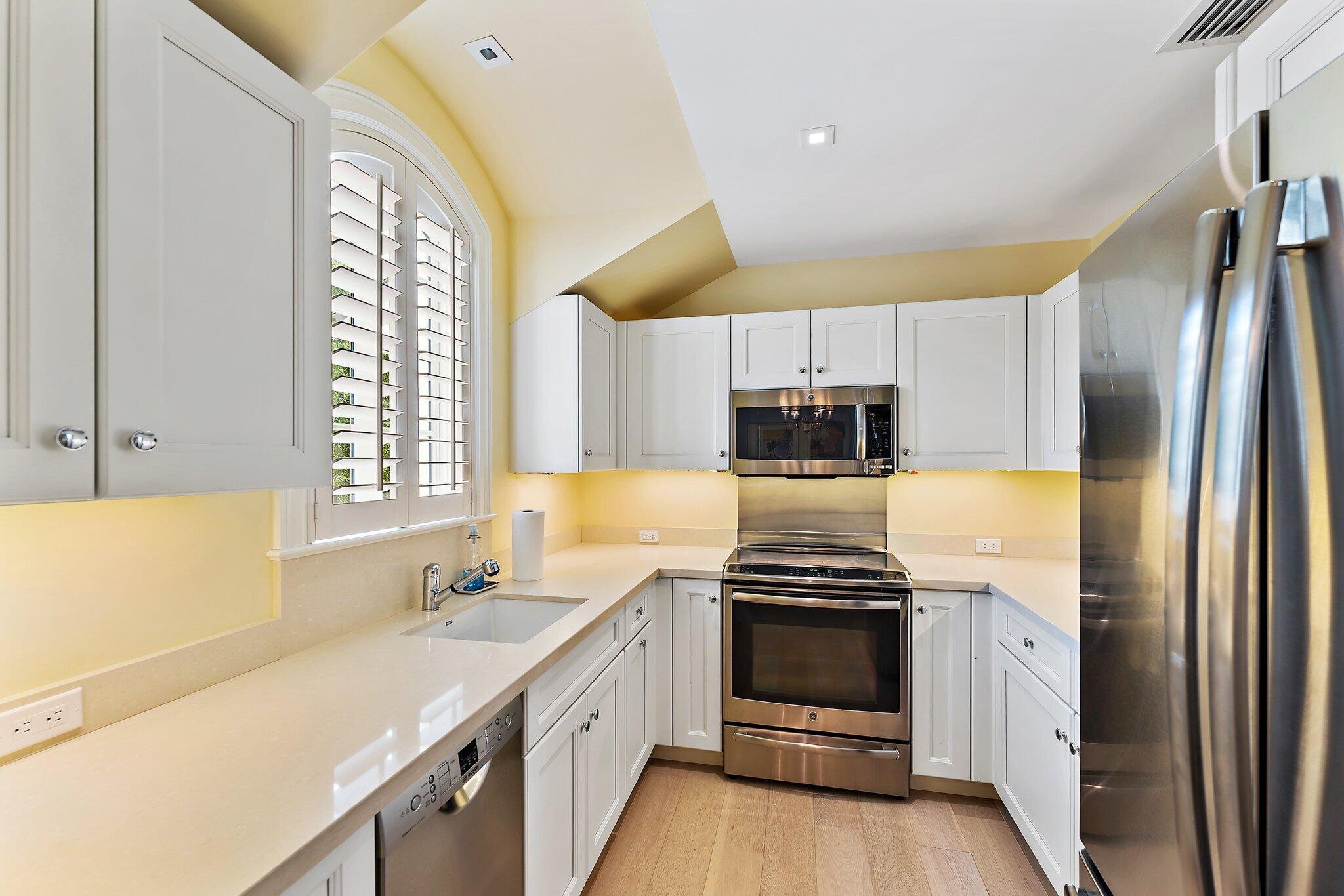 124 Bears Club Drive Jupiter, FL 33477 - Photo 52 of 67 a kitchen with stainless steel appliances a stove a sink and a refrigerator