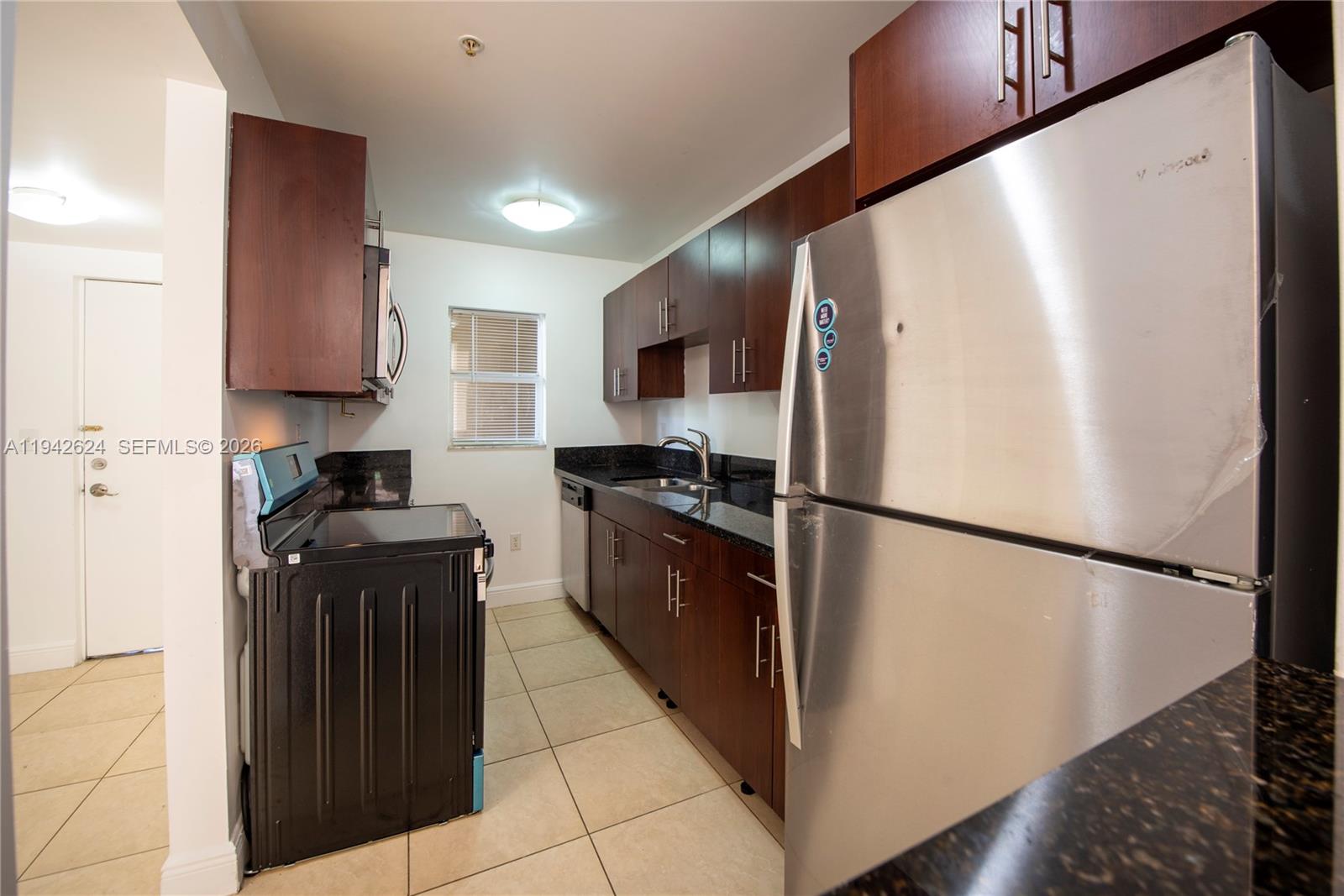 4137 Stirling Road, Unit 506 Dania Beach, FL 33314 - Photo 2 of 13 a kitchen with a refrigerator and a stove