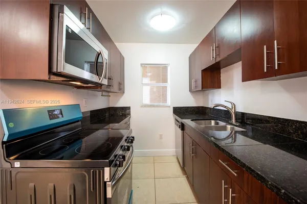 a kitchen with stainless steel appliances granite countertop a stove a sink and a microwave