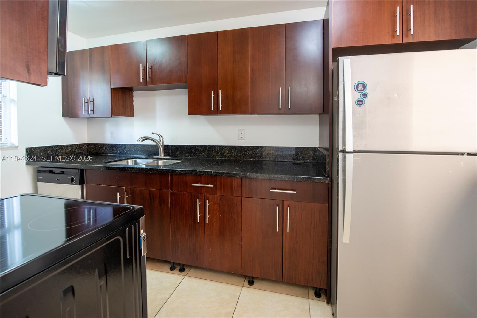4137 Stirling Road, Unit 506 Dania Beach, FL 33314 - Photo 4 of 13 a kitchen with a refrigerator and a sink
