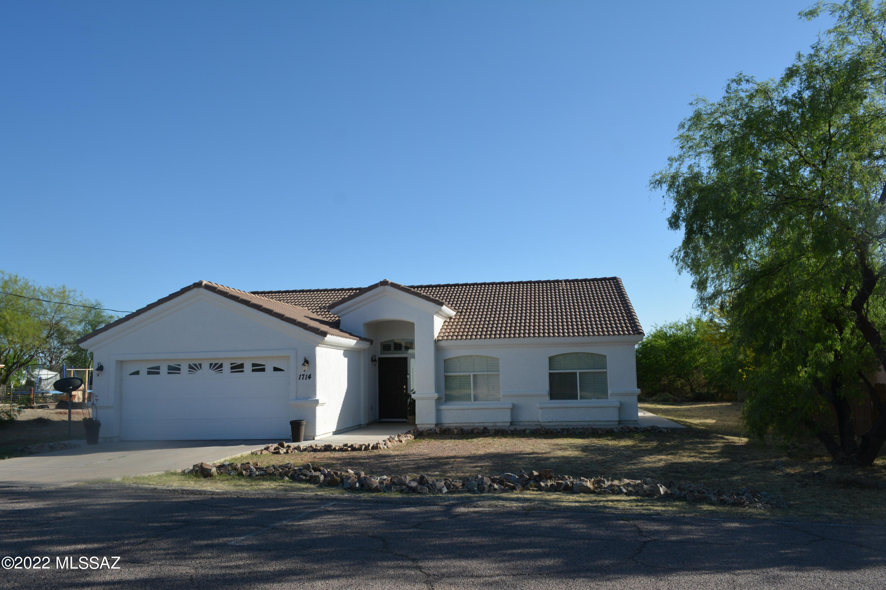 1714 Camino Rivera Rio Rico, AZ 85648 - Photo 2 of 26 a front view of a house with a yard