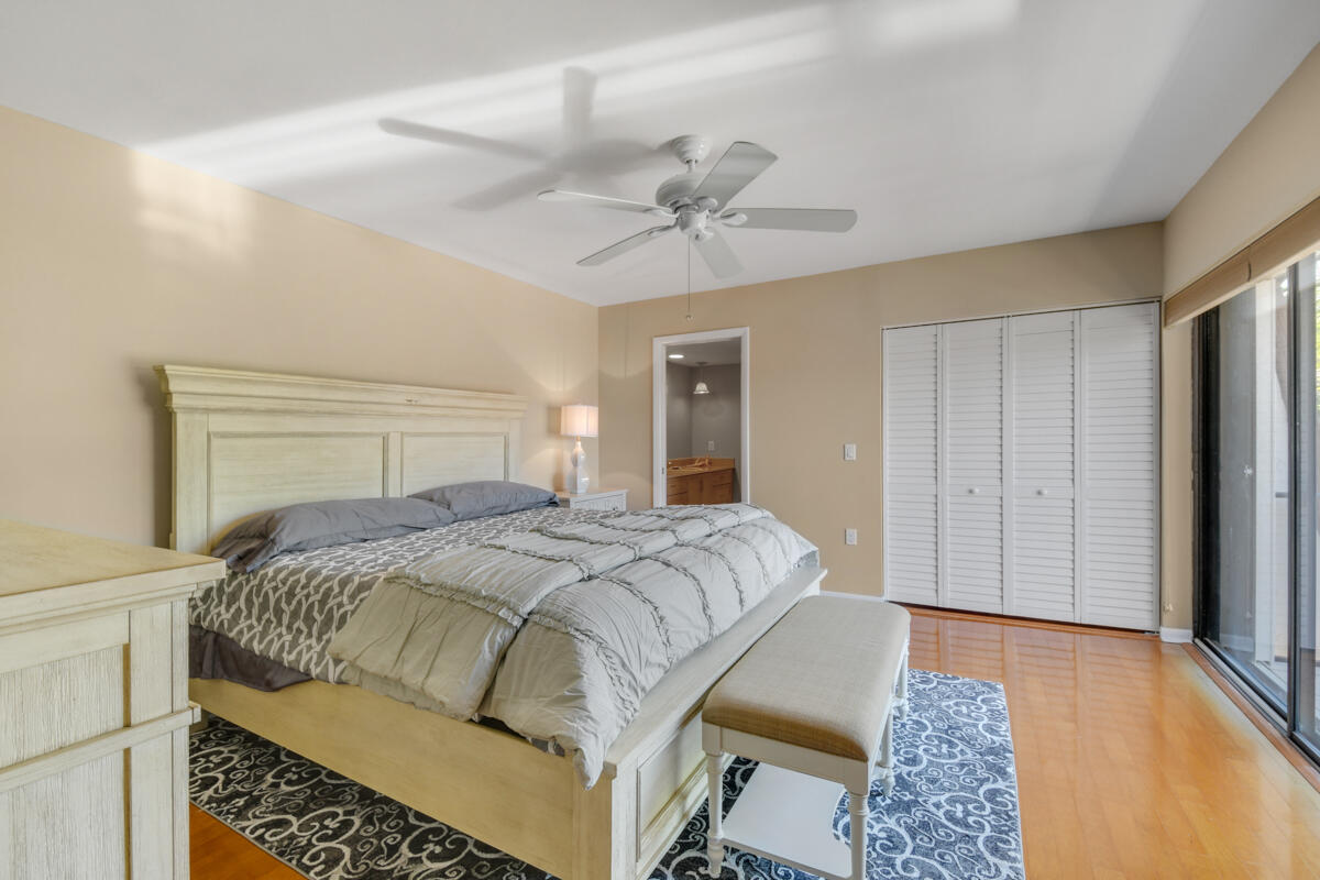 3900 County Line Road, Unit 9D Tequesta, FL 33469 - Photo 22 of 34 a bedroom with a bed and wooden floor