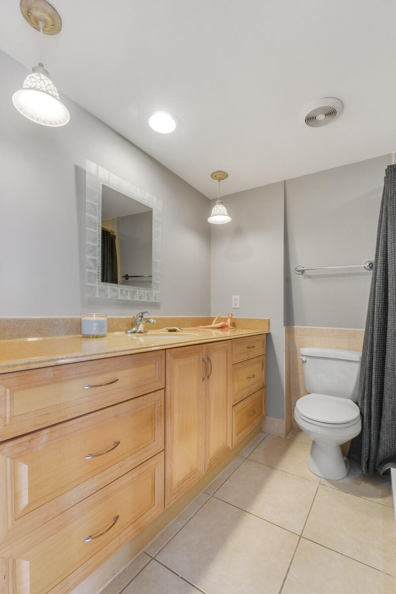 3900 County Line Road, Unit 9D Tequesta, FL 33469 - Photo 23 of 34 a bathroom with a toilet sink and mirror