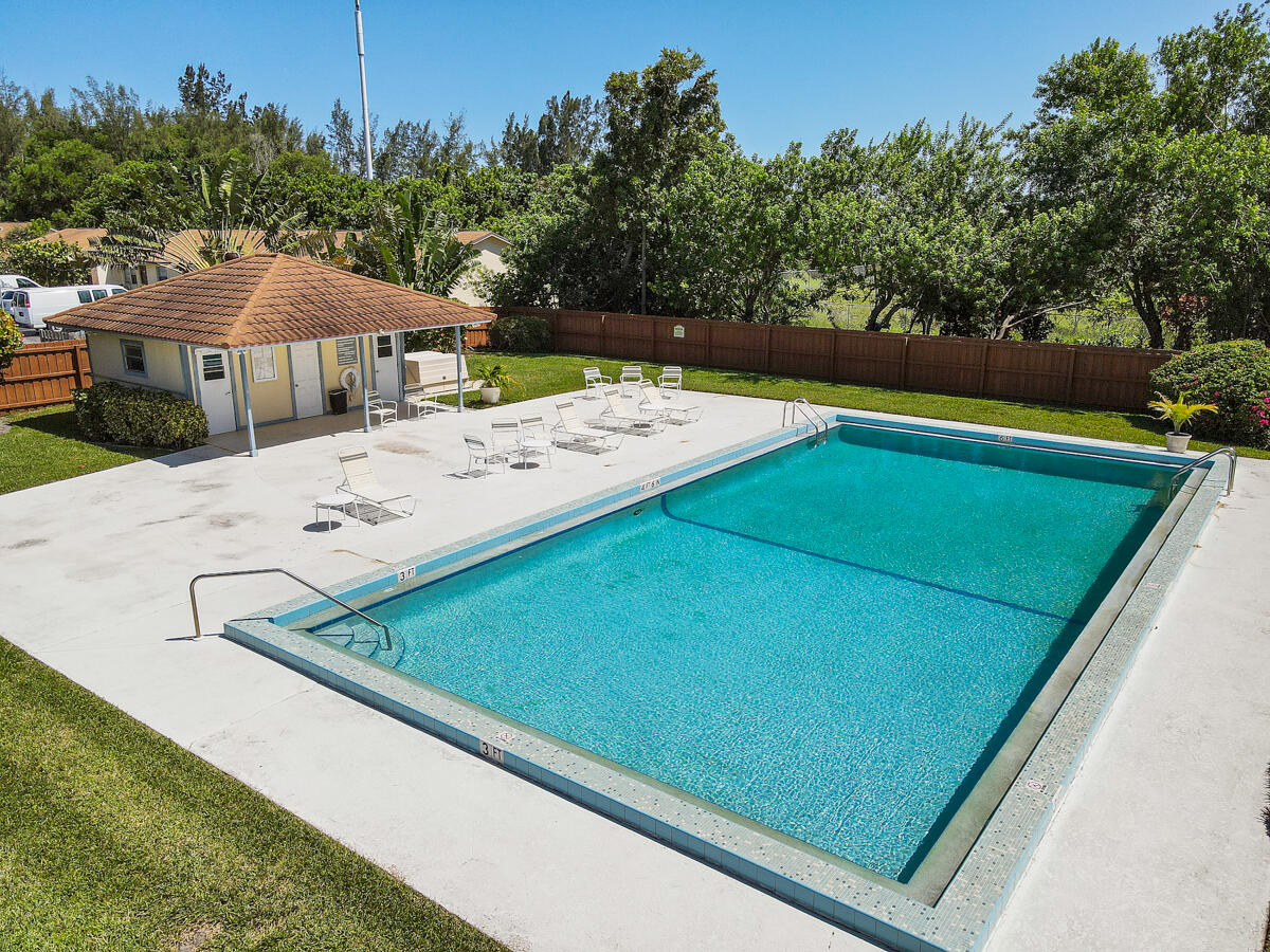 3900 County Line Road, Unit 9D Tequesta, FL 33469 - Photo 32 of 34 a view of a pool with a yard