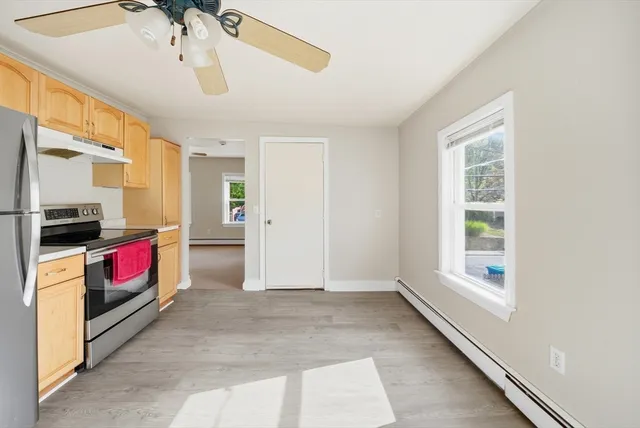 a living room with furniture and a refrigerator