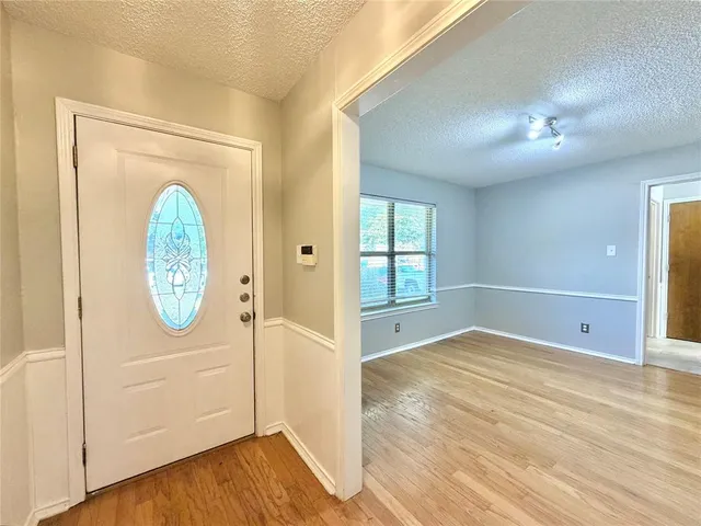 a view of a room with wooden floor door and windows