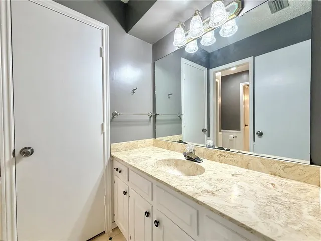 a bathroom with a granite countertop sink and a mirror