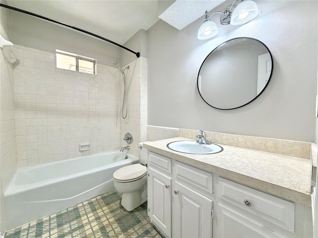 1821 Broadway Street Denton, TX 76201 - Photo 16 of 21 a bathroom with a sink a toilet and a mirror