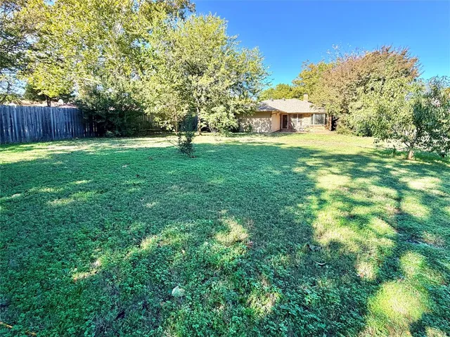 a view of a backyard with a garden and trees