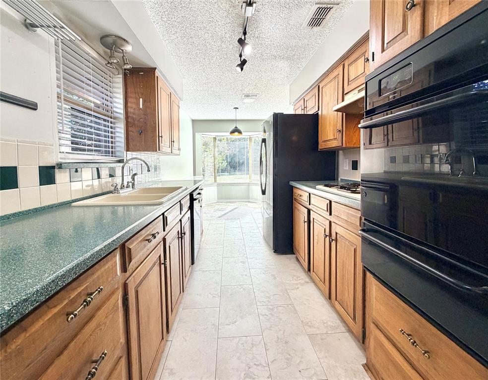 1821 Broadway Street Denton, TX 76201 - Photo 9 of 21 a kitchen with stainless steel appliances granite countertop counter space a sink and cabinets