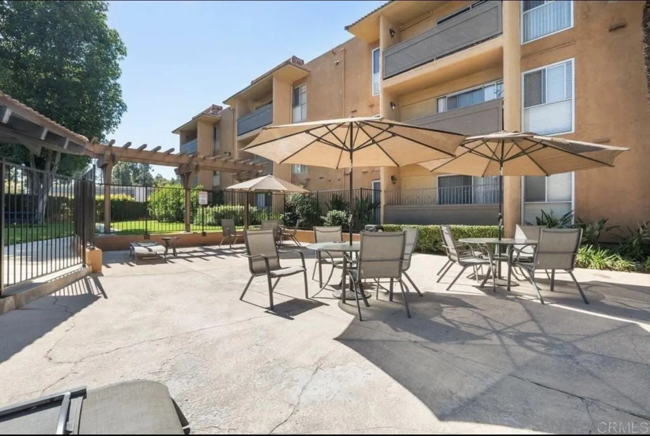 6911 Alvarado Road, Unit 20 San Diego, CA 92120 - Photo 22 of 28 a view of a patio with a table and chairs under an umbrella