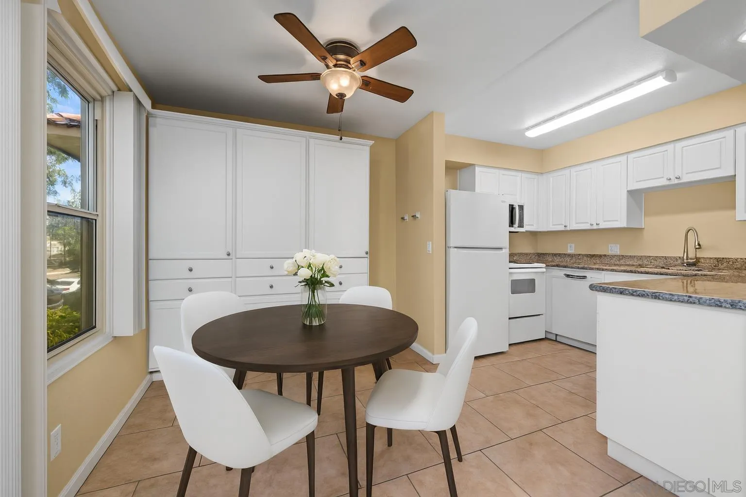 6911 Alvarado Road, Unit 20 San Diego, CA 92120 - Photo 6 of 28 a kitchen with stainless steel appliances kitchen island granite countertop a sink a stove a refrigerator a microwave oven with white cabinets and wooden floor