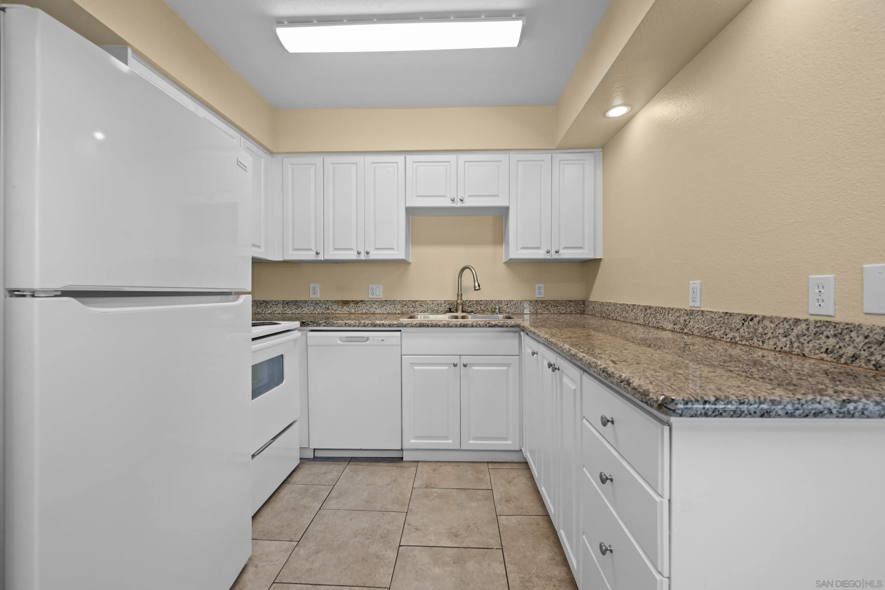 6911 Alvarado Road, Unit 20 San Diego, CA 92120 - Photo 7 of 28 a kitchen with granite countertop white cabinets and white appliances