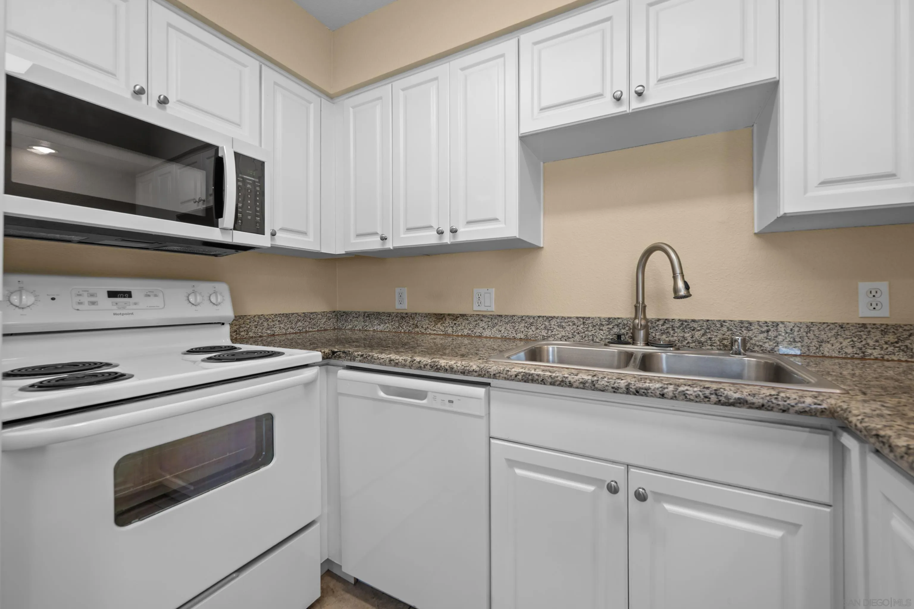 6911 Alvarado Road, Unit 20 San Diego, CA 92120 - Photo 8 of 28 a kitchen with granite countertop white cabinets and stainless steel appliances