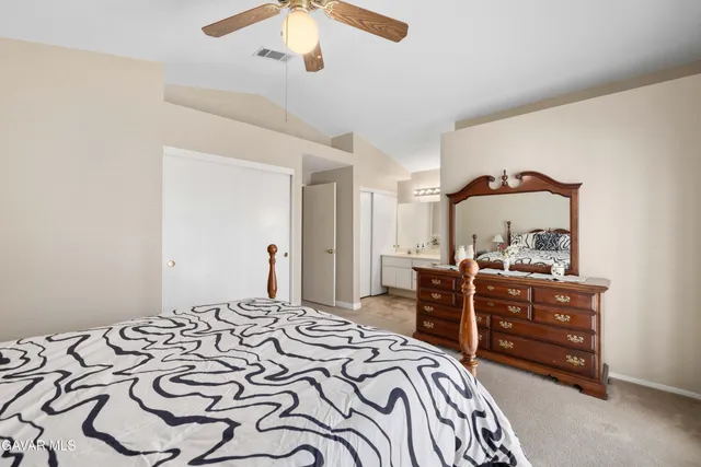 a bedroom with a bed and dresser with mirror