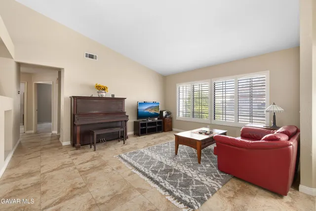 a living room with furniture a flat screen tv and a window