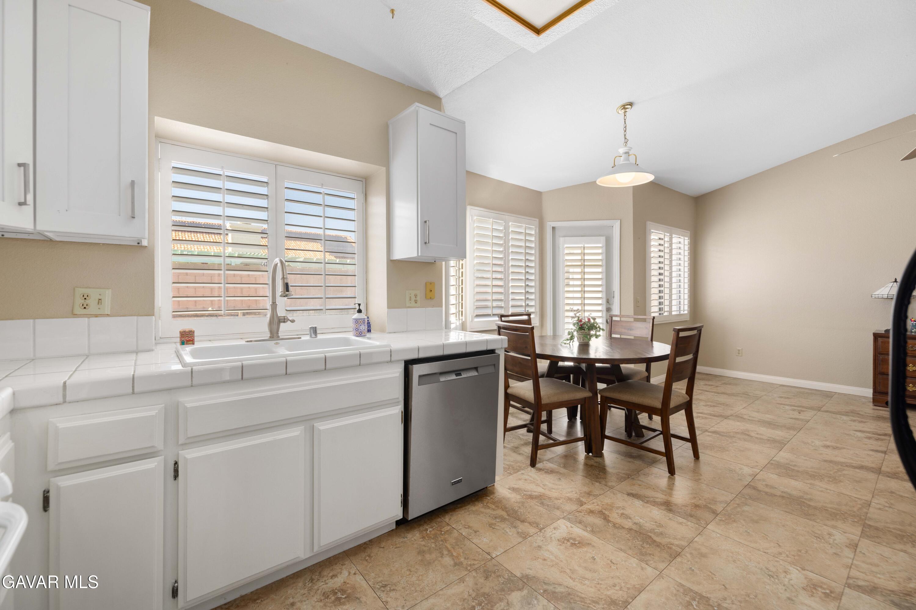 44239 Fenner Avenue Lancaster, CA 93536 - Photo 10 of 31 a kitchen with kitchen island granite countertop a sink a center island a stove and a window