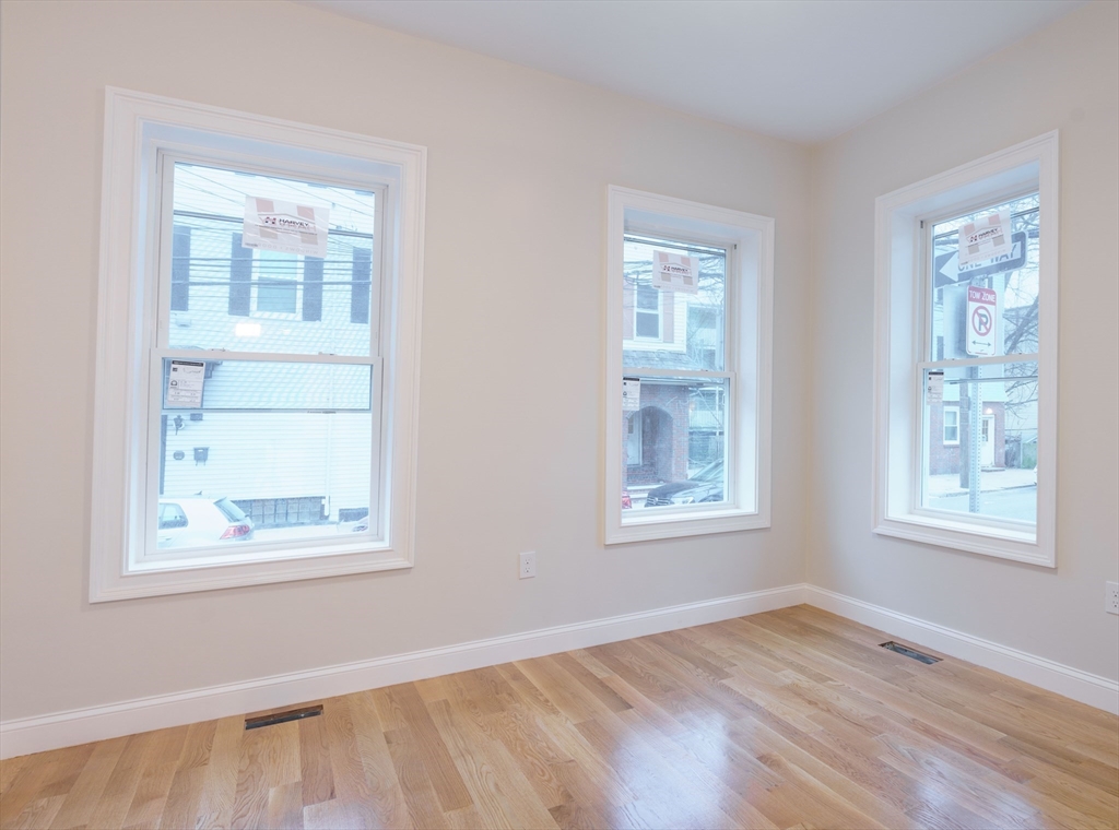 217 West 9th Street, Unit 1 Boston, MA 02127 - Photo 12 of 14 a view of an empty room with wooden floor and a window