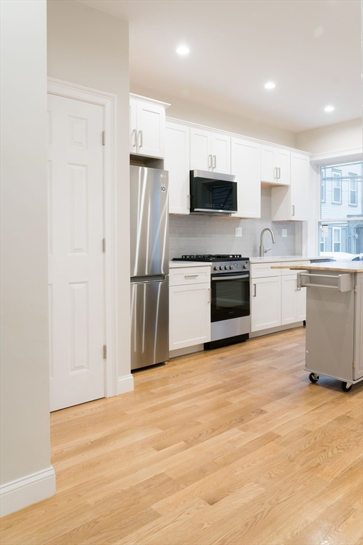 217 West 9th Street, Unit 1 Boston, MA 02127 - Photo 2 of 14 a kitchen with stainless steel appliances granite countertop a refrigerator and a stove top oven