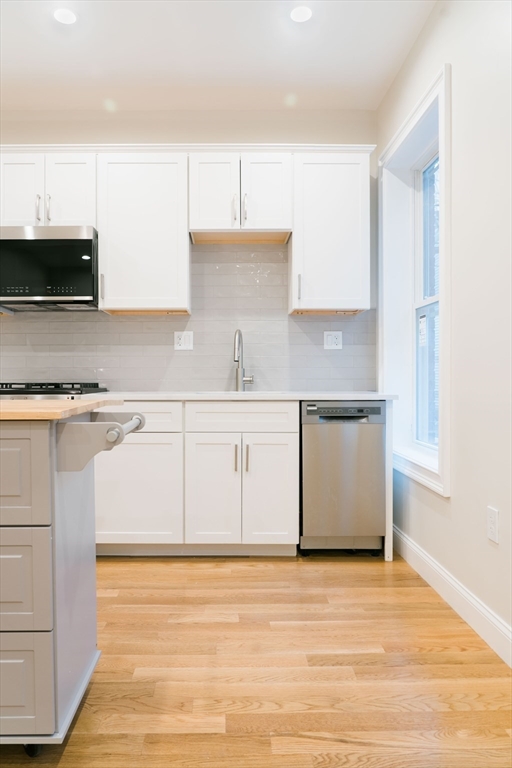 217 West 9th Street, Unit 1 Boston, MA 02127 - Photo 4 of 14 a kitchen with stainless steel appliances granite countertop a sink a stove and a refrigerator