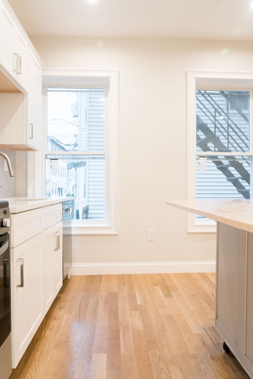 217 West 9th Street, Unit 1 Boston, MA 02127 - Photo 7 of 14 a view of a kitchen with wooden floor and a sink