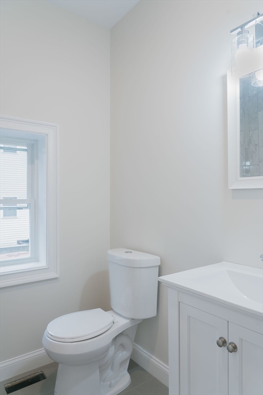217 West 9th Street, Unit 1 Boston, MA 02127 - Photo 8 of 14 a white toilet sitting next to a bathroom sink and vanity