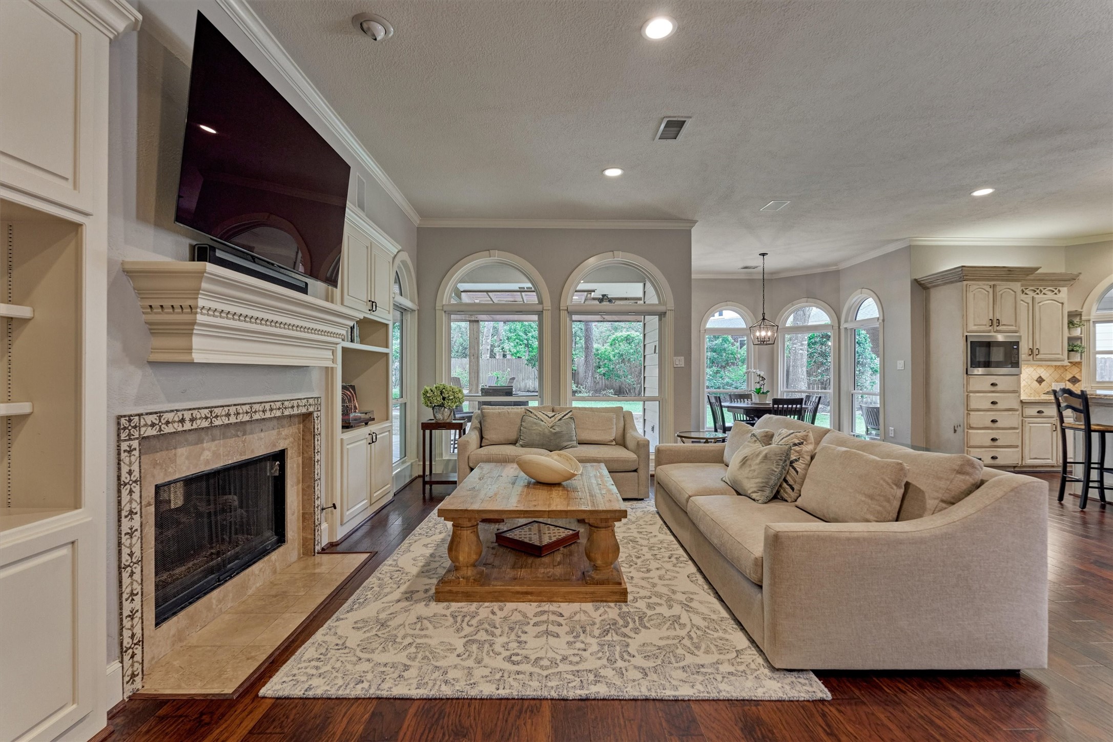 18 Treevine Court The Woodlands, TX 77381 - Photo 11 of 50 Cozy den with a dual-sided fireplace connecting to the formal living room and plenty of space to relax or entertain.