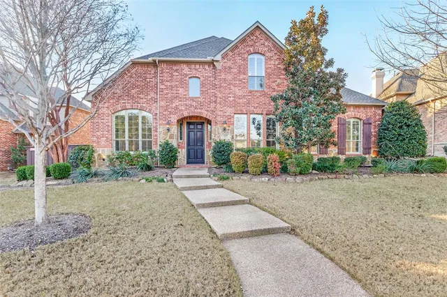 a front view of a house with yard and trees