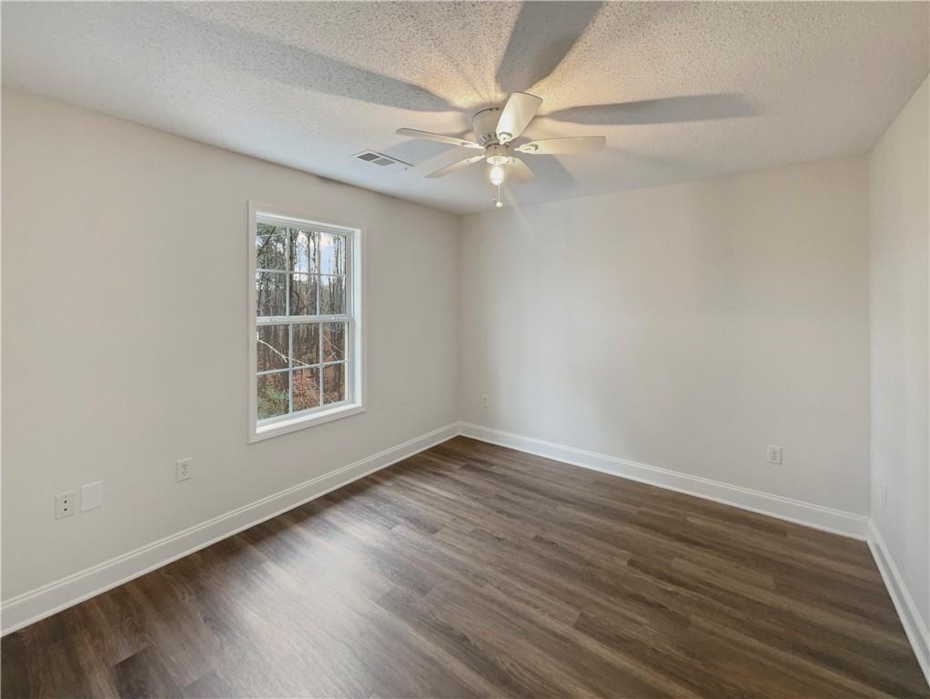 185 Thrasher Lane Jasper, GA 30143 - Photo 18 of 32 an empty room with wooden floor fan and windows