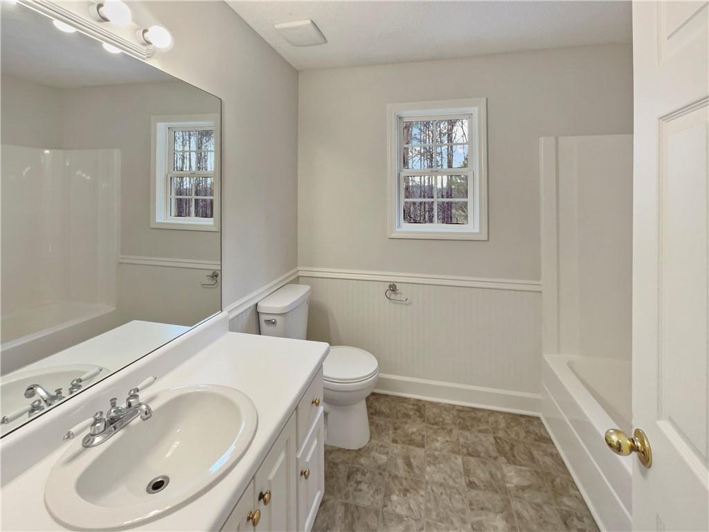 185 Thrasher Lane Jasper, GA 30143 - Photo 27 of 32 a bathroom with a sink a toilet and mirror