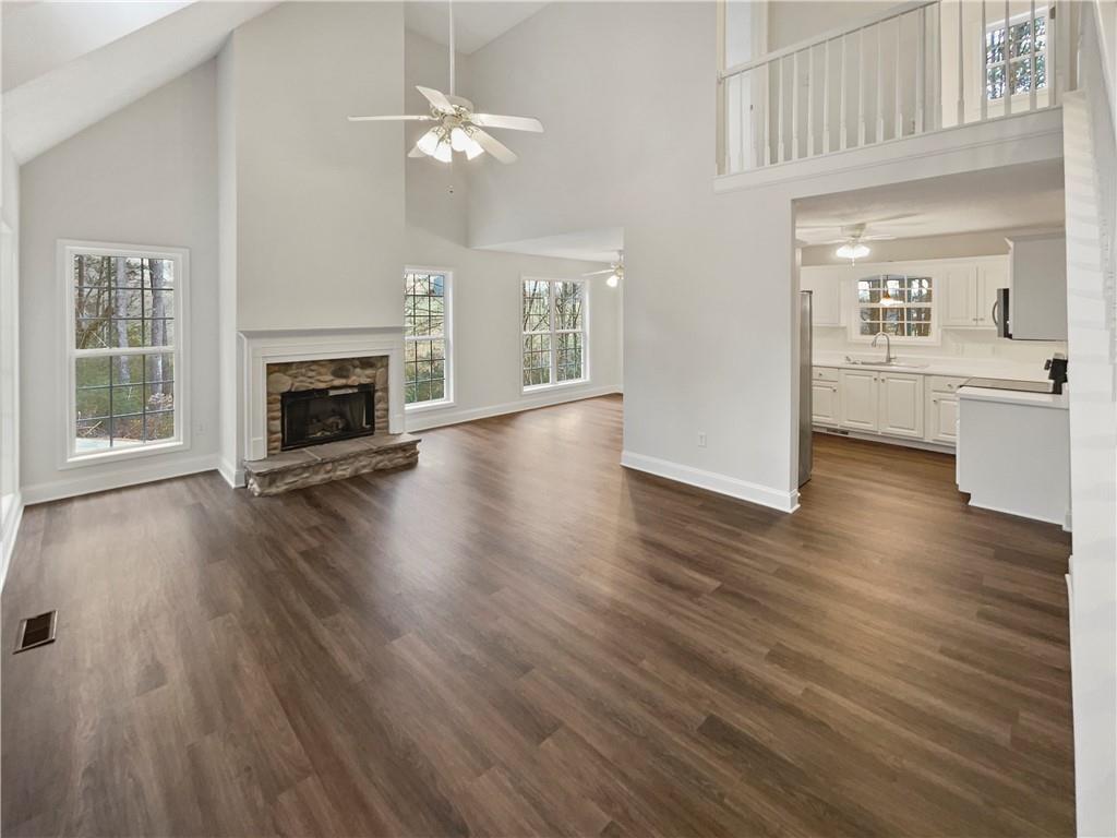 185 Thrasher Lane Jasper, GA 30143 - Photo 6 of 32 a view of a livingroom with wooden floor a fireplace and windows